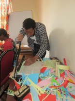 Aregahegn cuts the paper which will be turned into paper beads